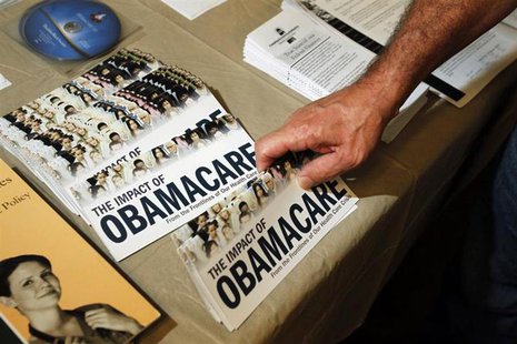 A Tea Party member reaches for a pamphlet titled "The Impact of Obamacare", at a "Food for Free Minds Tea Party Rally" in Littleton, New Ham A Tea Party member reaches for a pamphlet titled "The Impact of Obamacare", at a "Food for Free Minds Tea Party Rally" in Littleton, New Ham