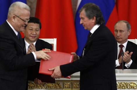 Russia's President Vladimir Putin (R, back) and his Chinese counterpart Xi Jinping (L, back) applaud while Rosneft President and Chairman of Russia's President Vladimir Putin (R, back) and his Chinese counterpart Xi Jinping (L, back) applaud while Rosneft President and Chairman of