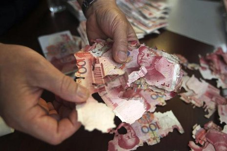 Damaged 100 yuan banknotes are seen at a branch of China Bank in Foshan, Guangdong province, June 5, 2013. REUTERS/Stringer Damaged 100 yuan banknotes are seen at a branch of China Bank in Foshan, Guangdong province, June 5, 2013. REUTERS/Stringer