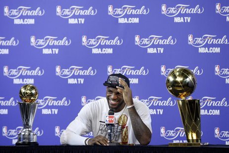 Miami Heat's LeBron James sits with the Larry O'Brien Trophy and the Bill Russell MVP Trophy after his team defeated the San Antonio Spurs i Miami Heat's LeBron James sits with the Larry O'Brien Trophy and the Bill Russell MVP Trophy after his team defeated the San Antonio Spurs i