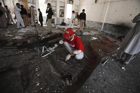 A rescue worker collects evidence from the site of a suicide bomb attack at a Shi'ite Muslim mosque in Peshawar June 21, 2013. REUTERS/Fayaz A rescue worker collects evidence from the site of a suicide bomb attack at a Shi'ite Muslim mosque in Peshawar June 21, 2013. REUTERS/Fayaz