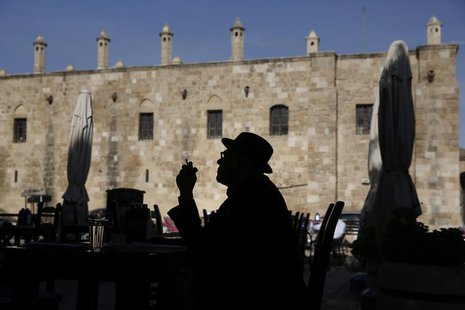 A man smoking a cigarette is silhouetted in front of Buyuk Han (The Great Inn) in Nicosia, Northern Cyprus March 25, 2013. REUTERS/Yorgos Ka A man smoking a cigarette is silhouetted in front of Buyuk Han (The Great Inn) in Nicosia, Northern Cyprus March 25, 2013. REUTERS/Yorgos Ka