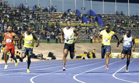 Usain Bolt (C) crosses the finish line ahead of (L-R) Asafa Powell, Nickel Ashmeade, Kamar Baley-Cole, and Nesta Garter to win the 100m men' Usain Bolt (C) crosses the finish line ahead of (L-R) Asafa Powell, Nickel Ashmeade, Kamar Baley-Cole, and Nesta Garter to win the 100m men'