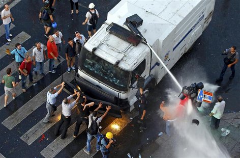Protesters try to stop an armored crowd control truck from which the riot police fire water cannon at Taksim Square in Istanbul June 22, 201 Protesters try to stop an armored crowd control truck from which the riot police fire water cannon at Taksim Square in Istanbul June 22, 201