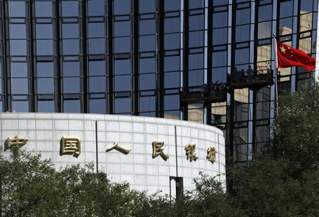 A Chinese national flag flies as workers clean the windows of the headquarters of the People's Bank of China, the country's central bank, in A Chinese national flag flies as workers clean the windows of the headquarters of the People's Bank of China, the country's central bank, in