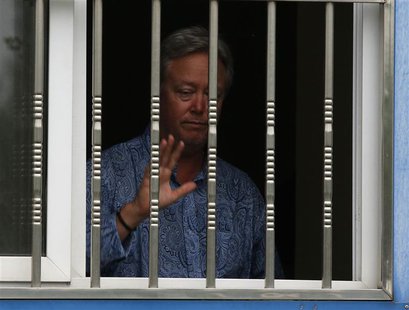 Chip Starnes, the co-owner of Coral Springs, gestures to journalists from a window as he is held hostage by workers inside his plant, on the Chip Starnes, the co-owner of Coral Springs, gestures to journalists from a window as he is held hostage by workers inside his plant, on the