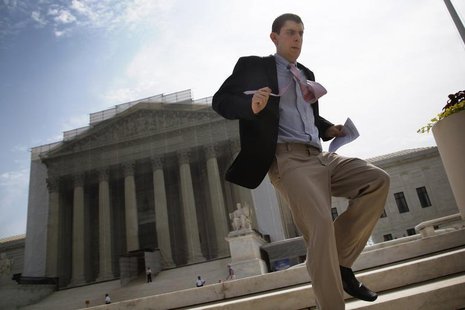 A television news producer sprints down the steps from the U.S. Supreme Court building with their printed rulings in cases heard earlier thi A television news producer sprints down the steps from the U.S. Supreme Court building with their printed rulings in cases heard earlier thi