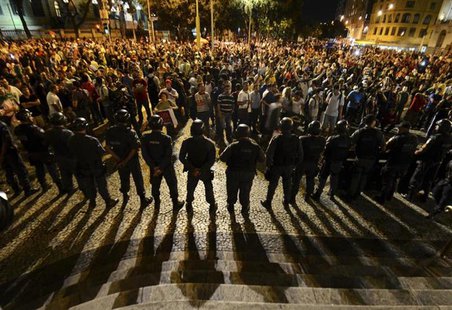 Demonstrators gather during a protest as police officers stand guard in central Rio de Janeiro June 24, 2013. REUTERS/Lucas Landau Demonstrators gather during a protest as police officers stand guard in central Rio de Janeiro June 24, 2013. REUTERS/Lucas Landau