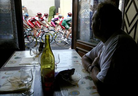 A man in a cafe looks out of the window at a pack of riders making their way through the 230-km (143-mile) sixth stage of the Tour de France A man in a cafe looks out of the window at a pack of riders making their way through the 230-km (143-mile) sixth stage of the Tour de France