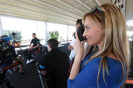 Michelle Cound (R), girlfriend of British cyclist Chris Froome (rear L) of Team Sky, takes a photo during his interview with the media in Ni Michelle Cound (R), girlfriend of British cyclist Chris Froome (rear L) of Team Sky, takes a photo during his interview with the media in Ni