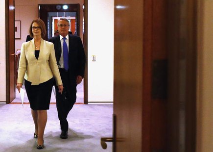 Australian Prime Minister Julia Gillard (L) walks into the Cabinet Room with Treasurer Wayne Swan at Parliament House in Canberra May 13, 20 Australian Prime Minister Julia Gillard (L) walks into the Cabinet Room with Treasurer Wayne Swan at Parliament House in Canberra May 13, 20