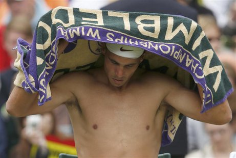 Rafael Nadal of Spain wipes himself with a towel during his men's singles tennis match against Steve Darcis of Belgium at the Wimbledon Tenn Rafael Nadal of Spain wipes himself with a towel during his men's singles tennis match against Steve Darcis of Belgium at the Wimbledon Tenn