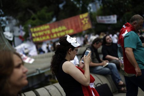 A protester uses her mobile device as she walks at Gezi Park on Taksim Square in Istanbul June 6, 2013. REUTERS/Stoyan Nenov A protester uses her mobile device as she walks at Gezi Park on Taksim Square in Istanbul June 6, 2013. REUTERS/Stoyan Nenov