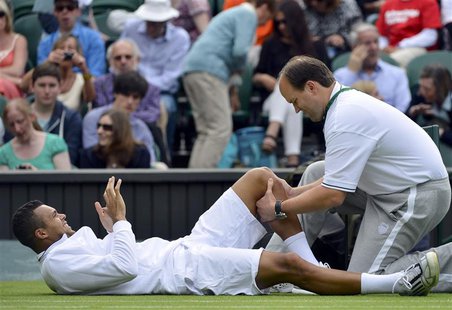Jo-Wilfried Tsonga of France receives treatment during his men's singles tennis match against Ernests Gulbis of Latvia at the Wimbledon Tenn Jo-Wilfried Tsonga of France receives treatment during his men's singles tennis match against Ernests Gulbis of Latvia at the Wimbledon Tenn