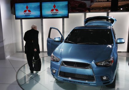 A journalist inspects the 2011 Mitsubishi Outlander sport compact SUV at the New York International Auto Show in New York April 1, 2010. REU A journalist inspects the 2011 Mitsubishi Outlander sport compact SUV at the New York International Auto Show in New York April 1, 2010. REU