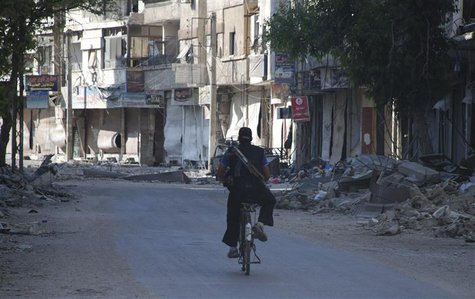 A Free Syrian Army fighter rides his bicycle in Daraya town near Damascus June 20, 2013. REUTERS/Mohamed Demashki A Free Syrian Army fighter rides his bicycle in Daraya town near Damascus June 20, 2013. REUTERS/Mohamed Demashki