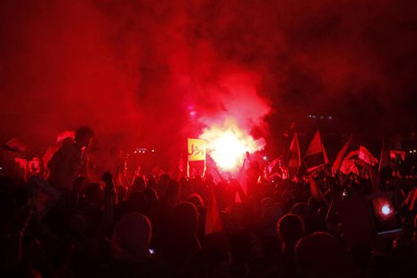 Protesters with flags and a banner reading "Leave" gather near a lit flare as they chant anti-Mursi and anti-Muslim Brotherhood slogans in T Protesters with flags and a banner reading "Leave" gather near a lit flare as they chant anti-Mursi and anti-Muslim Brotherhood slogans in T