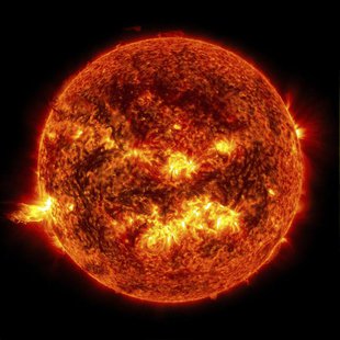 The bright light of a solar flare on the left side of the sun and an eruption of solar material shooting through the sun’s atmosphere, calle The bright light of a solar flare on the left side of the sun and an eruption of solar material shooting through the sun’s atmosphere, calle