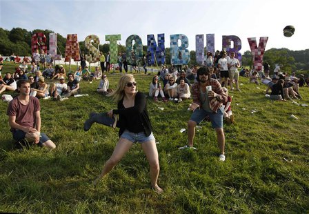 Festival goers play baseball, batting a beer can with a wellington boot, on the first day of Glastonbury music festival at Worthy Farm in So Festival goers play baseball, batting a beer can with a wellington boot, on the first day of Glastonbury music festival at Worthy Farm in So