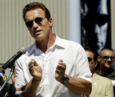 With a poster from his latest film "Terminator 3" in the background, actor Arnold Schwarzenegger applauds youths in attendance at opening ce With a poster from his latest film "Terminator 3" in the background, actor Arnold Schwarzenegger applauds youths in attendance at opening ce