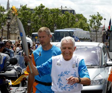 Former French Athletism champion Alain Mimoun holds the Olympic Flame during Day 21 of the Athens 2004 Olympic Torch Relay, June 25, 2004 in Former French Athletism champion Alain Mimoun holds the Olympic Flame during Day 21 of the Athens 2004 Olympic Torch Relay, June 25, 2004 in