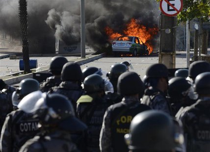 A vehicle is set on fire near riot policemen during a protest near the Estadio Castelao, where the Confederations Cup semi-final match betwe A vehicle is set on fire near riot policemen during a protest near the Estadio Castelao, where the Confederations Cup semi-final match betwe