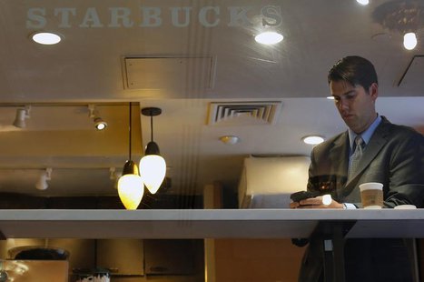 A man looks at his phone in a Starbucks store in New York June 25, 2013. REUTERS/Brendan McDermid A man looks at his phone in a Starbucks store in New York June 25, 2013. REUTERS/Brendan McDermid