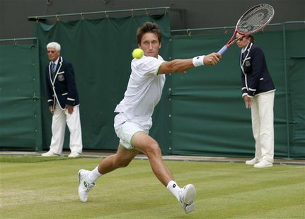 Sergiy Stakhovsky of Ukraine hits a return to Jurgen Melzer of Austria during their men's singles tennis match at the Wimbledon Tennis Champ Sergiy Stakhovsky of Ukraine hits a return to Jurgen Melzer of Austria during their men's singles tennis match at the Wimbledon Tennis Champ