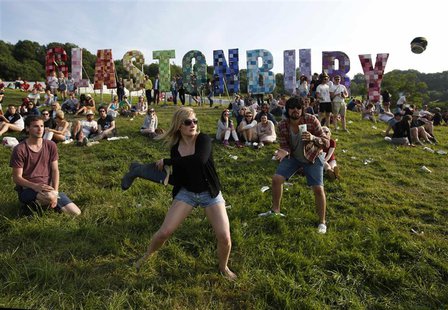 Festival goers play rounders with a wellington boot and a beer can on the first day of Glastonbury music festival at Worthy Farm in Somerset Festival goers play rounders with a wellington boot and a beer can on the first day of Glastonbury music festival at Worthy Farm in Somerset
