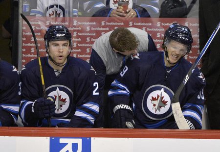 Winnipeg Jets' Tobias Enstrom (R) is attended to on the bench after being injured against the Buffalo Sabres during the first period of thei Winnipeg Jets' Tobias Enstrom (R) is attended to on the bench after being injured against the Buffalo Sabres during the first period of thei