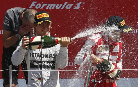 Mercedes Formula One driver Nico Rosberg (L) of Germany celebrates after winning the British Grand Prix with third placed Ferrari driver Fer Mercedes Formula One driver Nico Rosberg (L) of Germany celebrates after winning the British Grand Prix with third placed Ferrari driver Fer