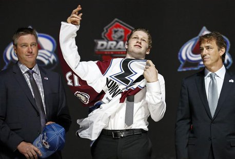Nathan Mackinnon (C) puts on a Colorado Avalanche jersey after he was selected by the Avalanche as the first overall pick in the 2013 Nation Nathan Mackinnon (C) puts on a Colorado Avalanche jersey after he was selected by the Avalanche as the first overall pick in the 2013 Nation