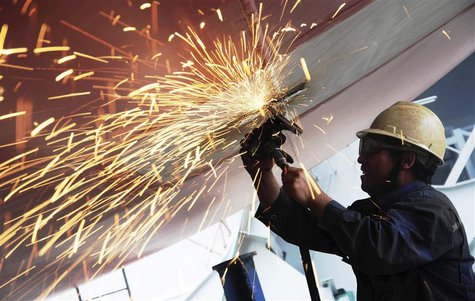 A labourer polishes the bottom of a cargo ship at a shipyard in Qingdao, Shandong province July 1, 2013. China's official purchasing manager A labourer polishes the bottom of a cargo ship at a shipyard in Qingdao, Shandong province July 1, 2013. China's official purchasing manager