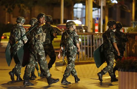 An armed paramilitary policeman gestures as he patrols with other policemen along a street in Kashgar, Xinjiang Uighur Autonomous Region Jun An armed paramilitary policeman gestures as he patrols with other policemen along a street in Kashgar, Xinjiang Uighur Autonomous Region Jun