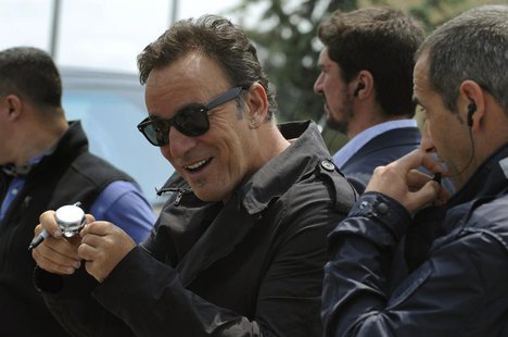 Singer Bruce Springsteen rings a bicycle bell which was given to him by a boy who waited with other fans outside his hotel to bid him farewe Singer Bruce Springsteen rings a bicycle bell which was given to him by a boy who waited with other fans outside his hotel to bid him farewe