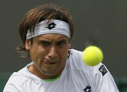 David Ferrer of Spain hits a return to Ivan Dodig of Croatia in their men's singles tennis match at the Wimbledon Tennis Championships, in L David Ferrer of Spain hits a return to Ivan Dodig of Croatia in their men's singles tennis match at the Wimbledon Tennis Championships, in L
