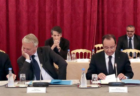 French President Francois Hollande (R) reacts as he studies documents as he sits with Prime Minister Jean-Marc Ayrault during a meeting with French President Francois Hollande (R) reacts as he studies documents as he sits with Prime Minister Jean-Marc Ayrault during a meeting with