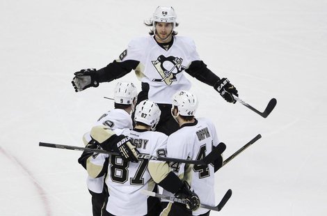 Pittsburgh Penguins Kris Letang (top) skates in to celebrate with teammates Pascal Dupuis, Sidney Crosby and Brooks Orpik (bottom L-R) after Pittsburgh Penguins Kris Letang (top) skates in to celebrate with teammates Pascal Dupuis, Sidney Crosby and Brooks Orpik (bottom L-R) after