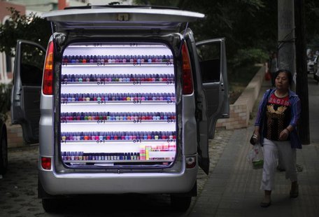 A woman walks past a van which has been converted into a stall selling nail polish on a sidewalk in Beijing, June 4, 2013. REUTERS/Barry Hua A woman walks past a van which has been converted into a stall selling nail polish on a sidewalk in Beijing, June 4, 2013. REUTERS/Barry Hua