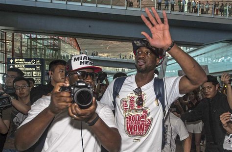NBA Miami Heat's basketball player Dwyane Wade (front R) waves to fans as he arrives at Beijing Capital International Airport in Beijing, Ju NBA Miami Heat's basketball player Dwyane Wade (front R) waves to fans as he arrives at Beijing Capital International Airport in Beijing, Ju