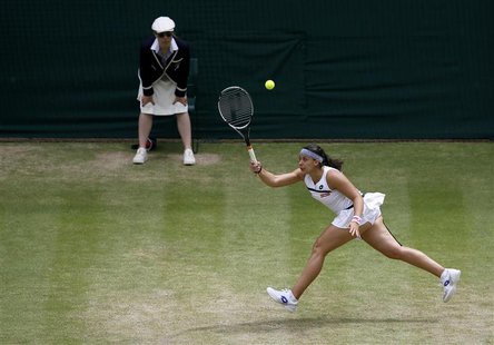 Marion Bartoli of France hits a return to Kirsten Flipkens of Belgium during their women's semi-final tennis match at the Wimbledon Tennis C Marion Bartoli of France hits a return to Kirsten Flipkens of Belgium during their women's semi-final tennis match at the Wimbledon Tennis C