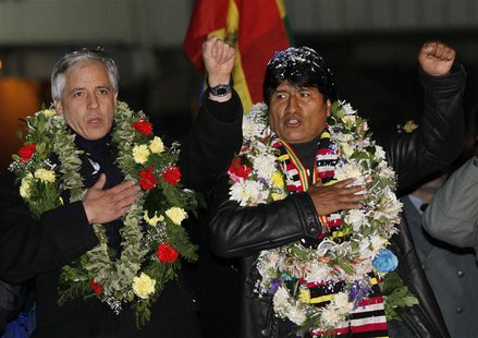 Bolivia's President Evo Morales (R) and Vice President Alvaro Garcia Linera sing the national anthem after Morales' arrival at the El Alto a Bolivia's President Evo Morales (R) and Vice President Alvaro Garcia Linera sing the national anthem after Morales' arrival at the El Alto a