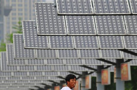 A man eats his breakfast as he walks under solar panels belonging to a solar power plant in Shenyang, Liaoning province June 5, 2013. REUTER A man eats his breakfast as he walks under solar panels belonging to a solar power plant in Shenyang, Liaoning province June 5, 2013. REUTER