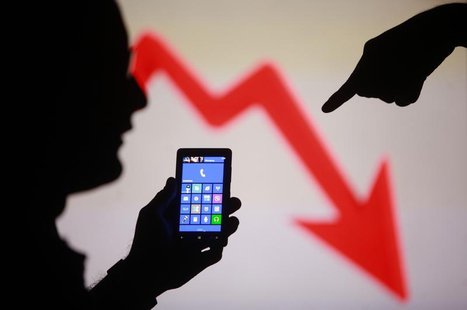 Men are silhouetted against a video screen with as they pose with a Nokia Lumia 820 smartphone in this photo illustration taken in the centr Men are silhouetted against a video screen with as they pose with a Nokia Lumia 820 smartphone in this photo illustration taken in the centr