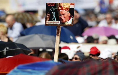 Faithful hold a poster of the late Pope John Paul II as Pope Francis leads a Pentecost vigil mass in Saint Peter's Square at the Vatican May Faithful hold a poster of the late Pope John Paul II as Pope Francis leads a Pentecost vigil mass in Saint Peter's Square at the Vatican May