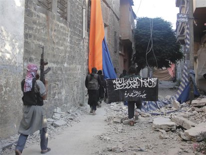 Free Syrian Army members accompanied by fighters from the Islamist Syrian rebel group Jabhat al-Nusra carry their weapons as one of them hol Free Syrian Army members accompanied by fighters from the Islamist Syrian rebel group Jabhat al-Nusra carry their weapons as one of them hol