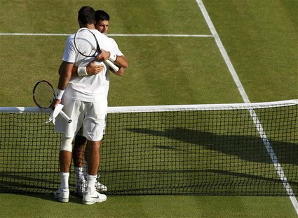 Novak Djokovic of Serbia (REAR) embraces Juan Martin del Potro of Argentina after defeating him in their men's semi-final tennis match at th Novak Djokovic of Serbia (REAR) embraces Juan Martin del Potro of Argentina after defeating him in their men's semi-final tennis match at th