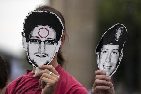 People hold portraits of former U.S. spy agency contractor Edward Snowden (L) and U.S. Army Private First Class Bradley Manning in front of People hold portraits of former U.S. spy agency contractor Edward Snowden (L) and U.S. Army Private First Class Bradley Manning in front of
