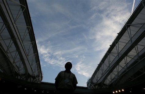 A guard stands on Centre Court as the roof is closed due to fading light during the men's semi-final tennis match between Andy Murray of Bri A guard stands on Centre Court as the roof is closed due to fading light during the men's semi-final tennis match between Andy Murray of Bri