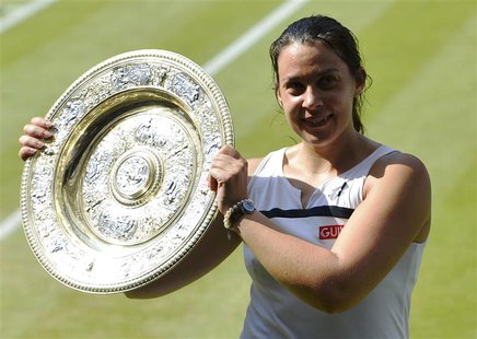 Marion Bartoli of France holds her winners trophy, the Venus Rosewater Dish, after defeating Sabine Lisicki of Germany in their women's sing Marion Bartoli of France holds her winners trophy, the Venus Rosewater Dish, after defeating Sabine Lisicki of Germany in their women's sing